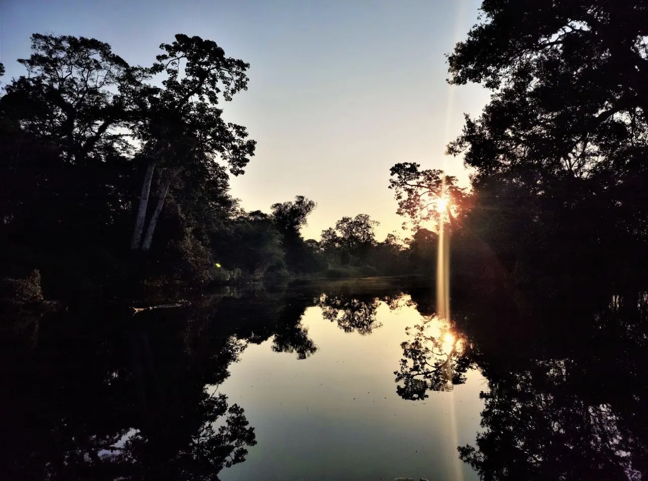 Sonnenuntergang, der sich im Fluss spiegelt